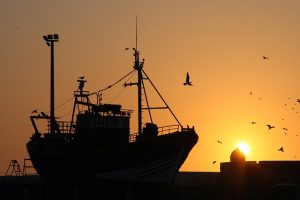 Silhouette of a fishing vessel against the sunset