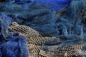 Blue fishing nets thrown into a pile